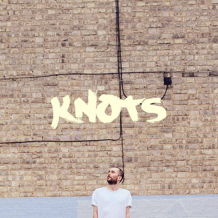 Jake stands in front of a wall again. It says 'Knots' above him.